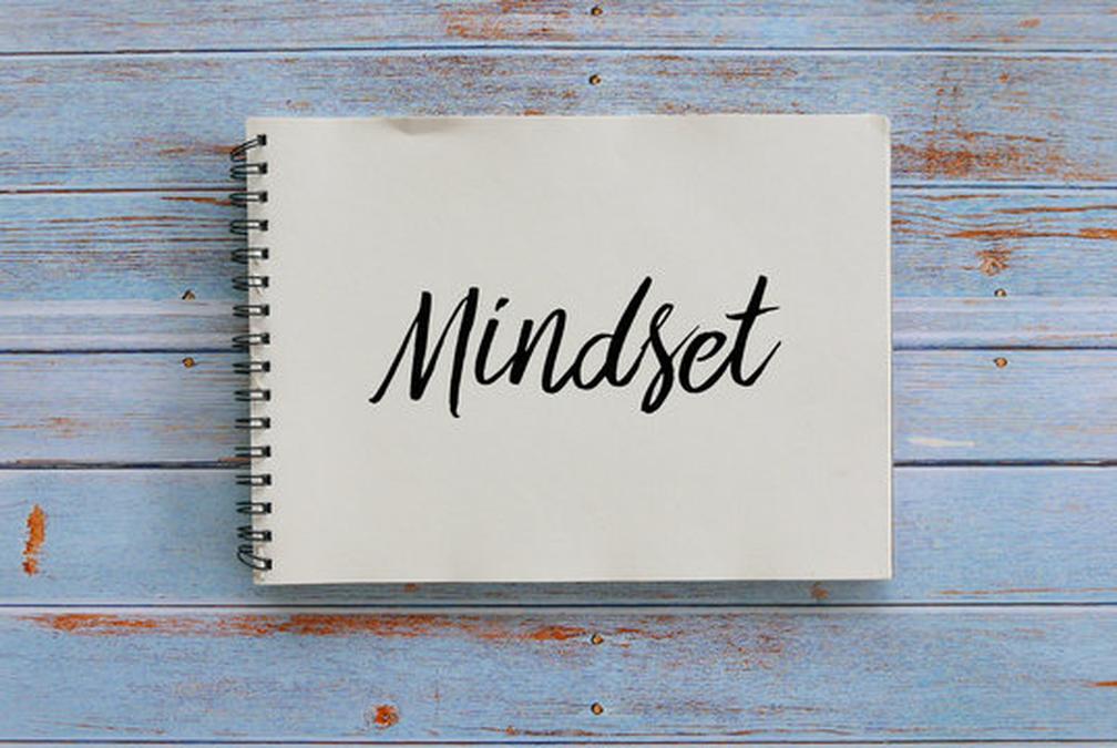 Top view of notebook written with Mindset on wooden background. - a notebook with the word minds wri